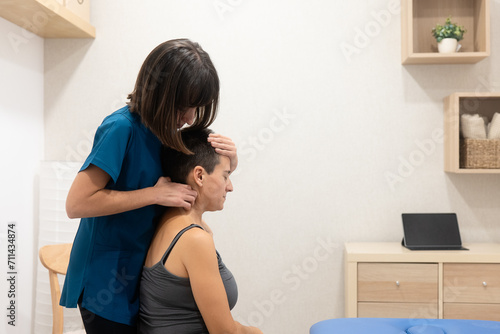 Physical therapist performing neck adjustment on patient photo
