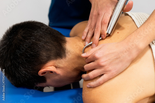 Physical therapy session using a steel massage tool photo