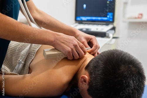 Patient undergoing ultrasound examination on back photo