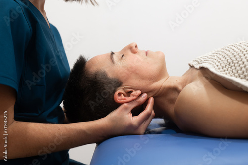 Chiropractor performing neck adjustment on patient photo