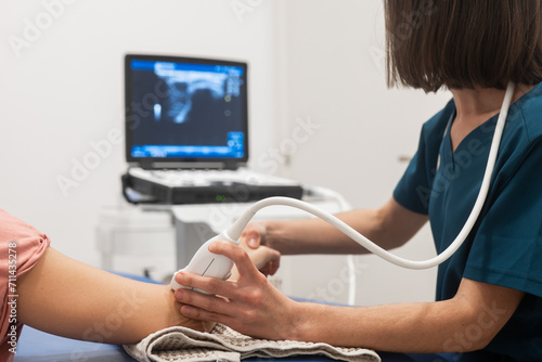 Healthcare professional conducting arm ultrasound exam photo