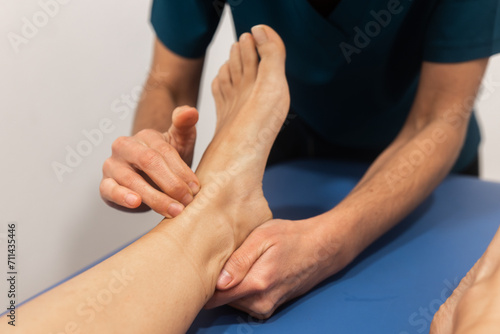 Physical therapist examining a patient's foot photo
