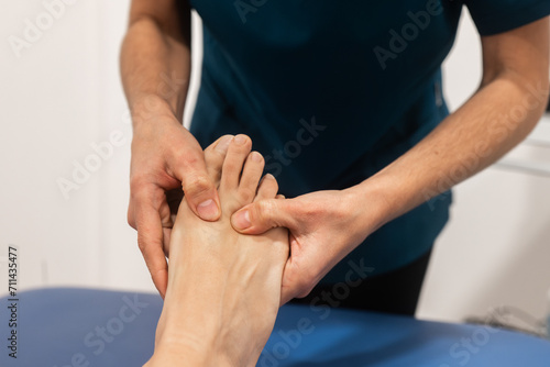 Physical therapist performing foot massage therapy photo