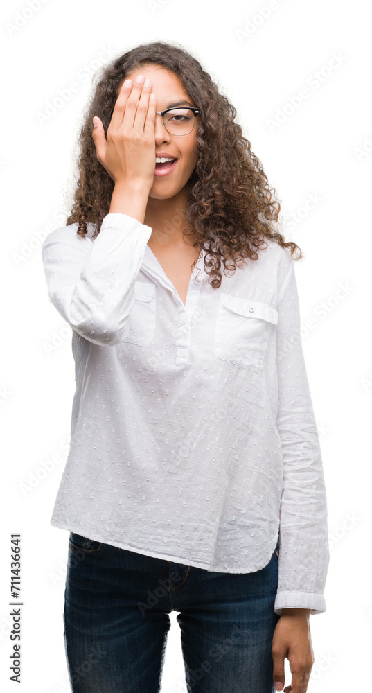 Beautiful young hispanic woman covering one eye with hand with confident smile on face and surprise emotion. Beautiful young hispanic woman covering one eye with hand with confident smile on face and surprise emotion.