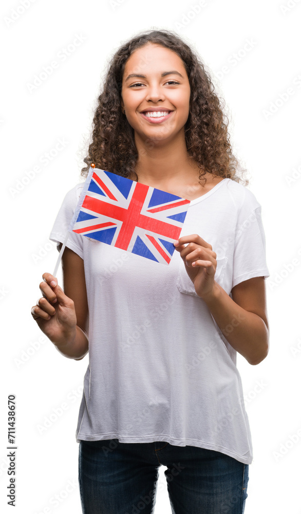 Young hispanic woman holding flag of United Kingdom with a happy face standing and smiling with a confident smile showing teeth Young hispanic woman holding flag of United Kingdom with a happy face standing and smiling with a confident smile showing teeth