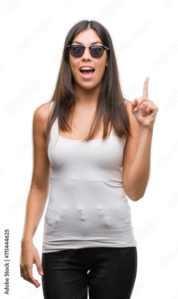 Young beautiful hispanic wearing sunglasses pointing finger up with successful idea. Exited and happy. Number one. Young beautiful hispanic wearing sunglasses pointing finger up with successful idea. Exited and happy. Number one.