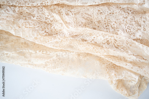 Texture of lace fabric. lace on a white background studio. thin fabric made of yarn or thread. usually one of cotton or silk, made by looping, twisting, or knitting thread in patterns