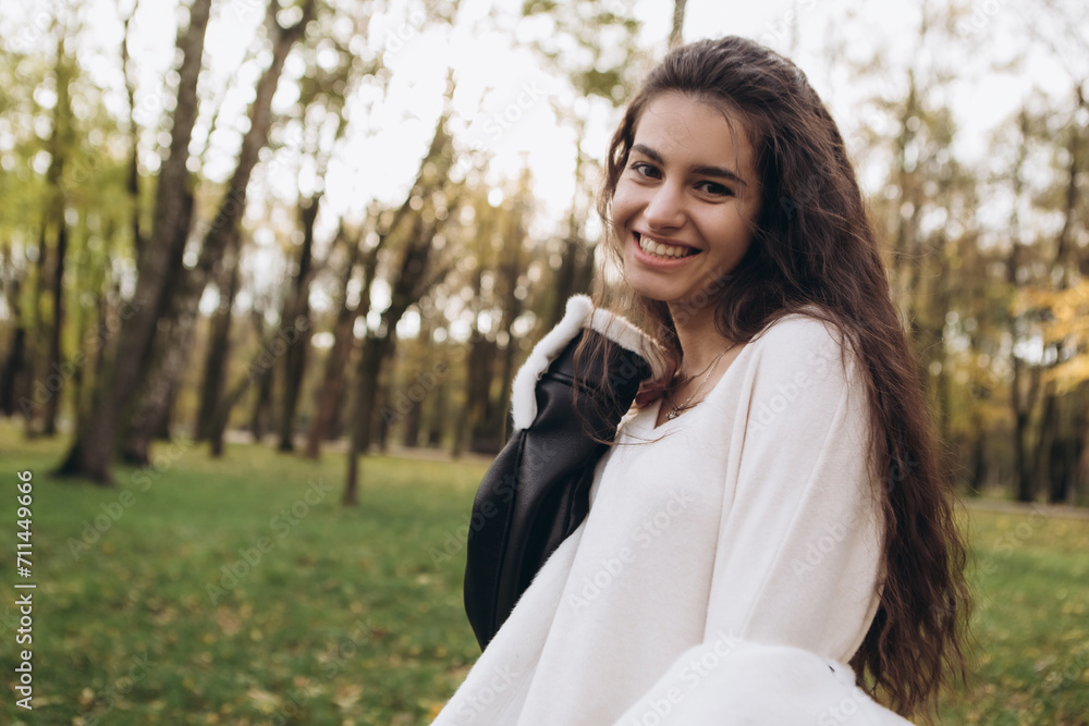 Attractive pretty woman walking outdoor, portrait of young lady in warm sunny autumn park season, fall, yellow orange red leaves, dressed leather wool fur jacket smiling having fun
Attractive pretty woman walking outdoor, portrait of young lady in warm sunny autumn park season, fall, yellow orange red leaves, dressed leather wool fur jacket smiling having fun