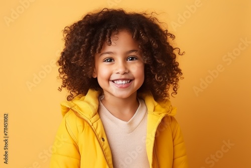 Portrait of a cute african american little girl smiling over yellow background