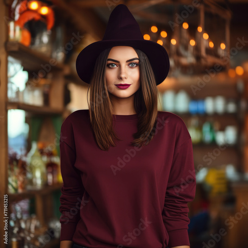 A beautiful girl wearing a blank mahogany sweatshirt, dark mahogany sweatshirt colour, and a witch hat Carnival halloween background
