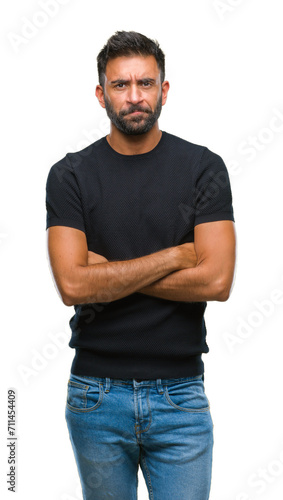 Adult hispanic man over isolated background skeptic and nervous, disapproving expression on face with crossed arms. Negative person.
