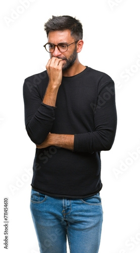 Adult hispanic man wearing glasses over isolated background looking stressed and nervous with hands on mouth biting nails. Anxiety problem.