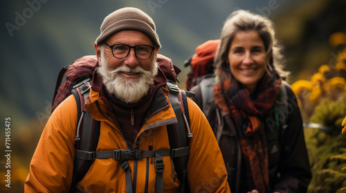 A couple of middle-aged tourists with a backpack on a hike in the mountains