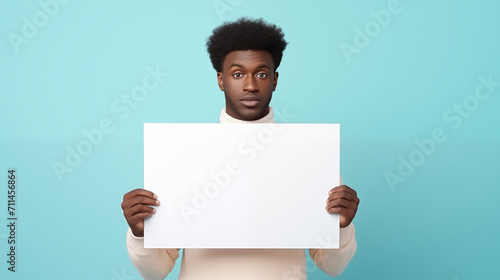 Homem afro segurando uma placa em branco isolado em um fundo azul turquesa  photo