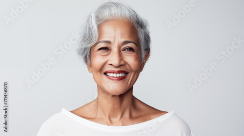 Mulher idosa afro de cabelo branco sorrindo isolada no fundo cinza claro photo