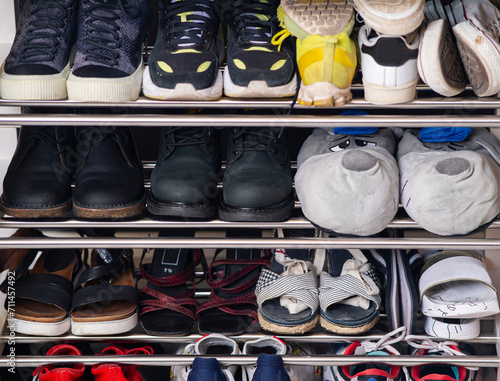 A collection of different shoes and sneakers of one family in a shoe rack