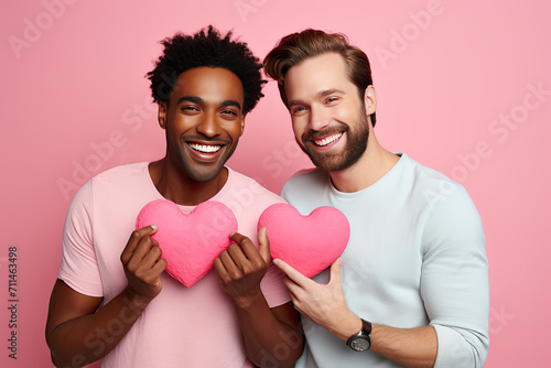 Happy love Two men making a heart shape with their hands, isolated on pink studio background