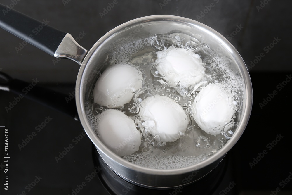 Chicken eggs boiling in saucepan on electric stove, above view Chicken eggs boiling in saucepan on electric stove, above view