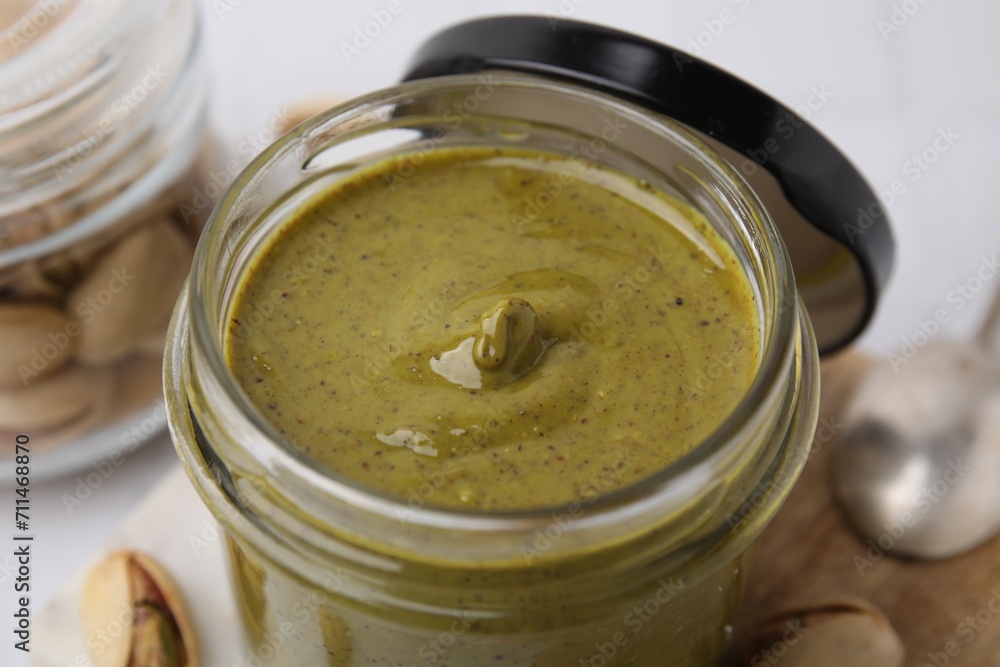 Tasty pistachio cream in jar on table, closeup Tasty pistachio cream in jar on table, closeup