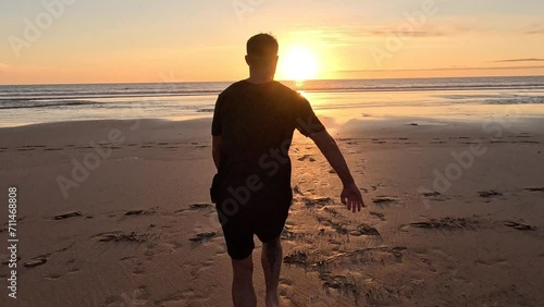 A man runs on the beach and does a backflip in slow motion in Morocco