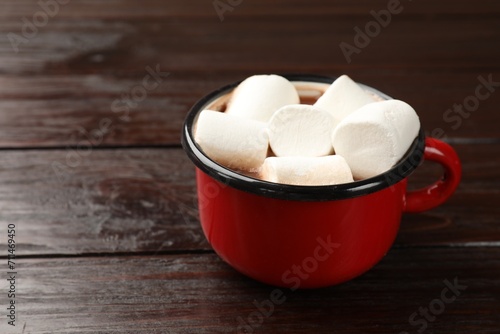 Tasty hot chocolate with marshmallows on wooden table, closeup. Space for text
