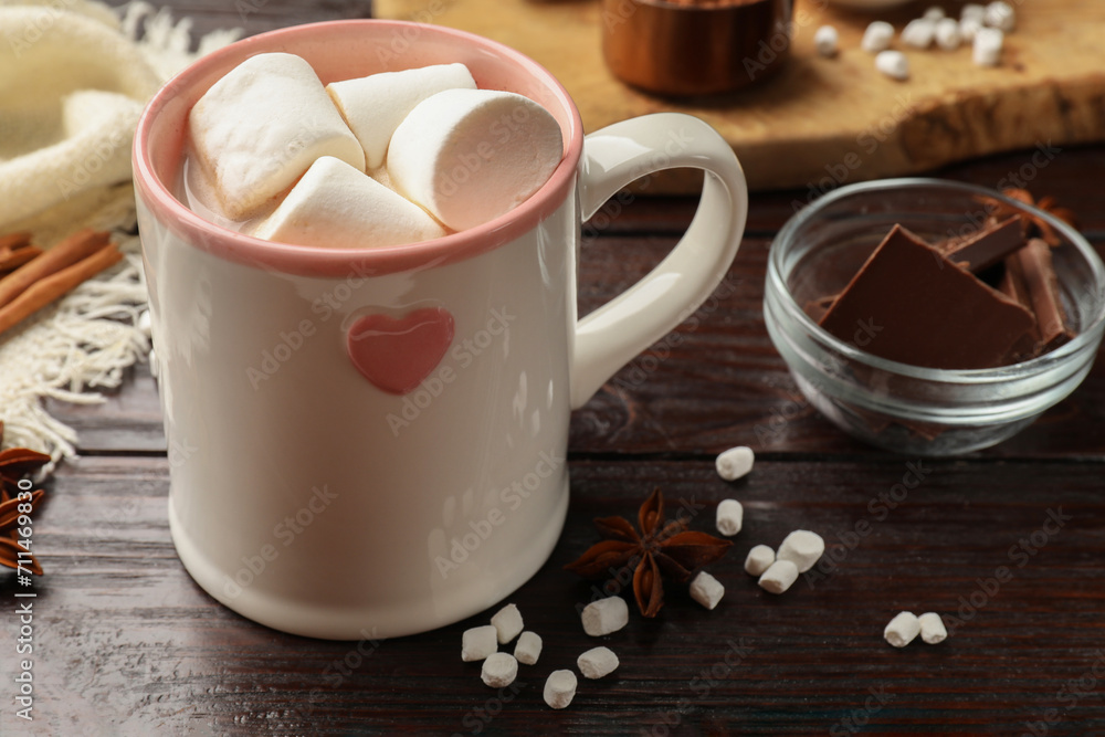 Tasty hot chocolate with marshmallows and ingredients on wooden table, closeup Tasty hot chocolate with marshmallows and ingredients on wooden table, closeup