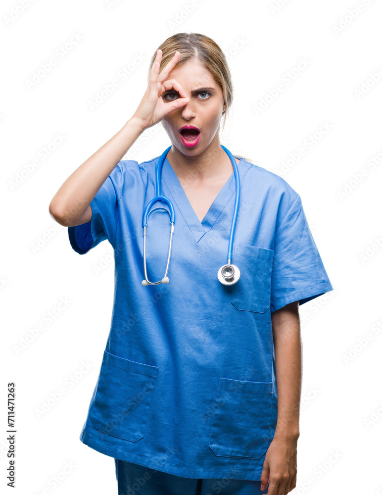 Young beautiful blonde doctor surgeon nurse woman over isolated background doing ok gesture shocked with surprised face, eye looking through fingers. Unbelieving expression. Young beautiful blonde doctor surgeon nurse woman over isolated background doing ok gesture shocked with surprised face, eye looking through fingers. Unbelieving expression.