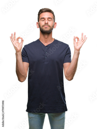 Young handsome man over isolated background relax and smiling with eyes closed doing meditation gesture with fingers. Yoga concept.