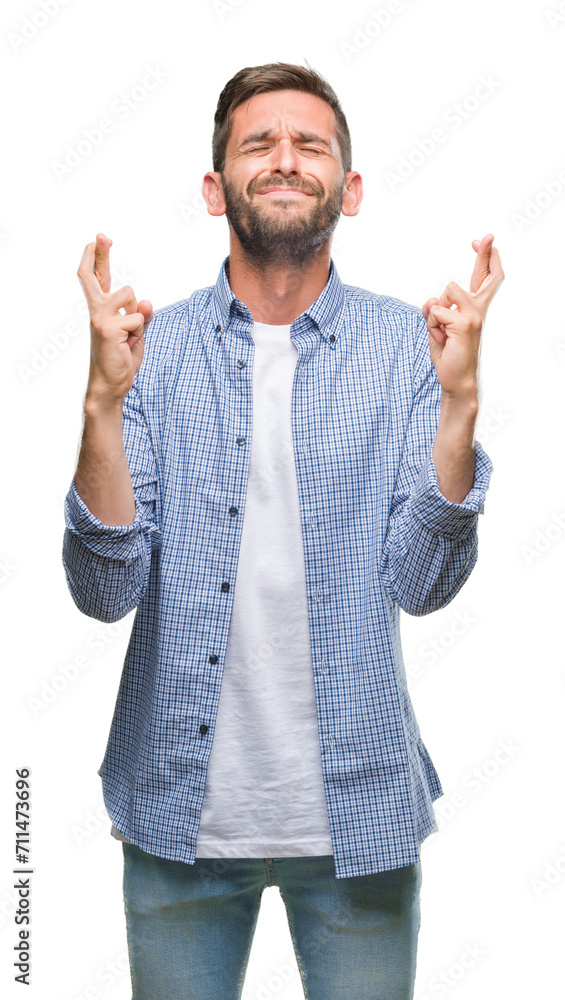 Young handsome man wearing white t-shirt over isolated background smiling crossing fingers with hope and eyes closed. Luck and superstitious concept. Young handsome man wearing white t-shirt over isolated background smiling crossing fingers with hope and eyes closed. Luck and superstitious concept.