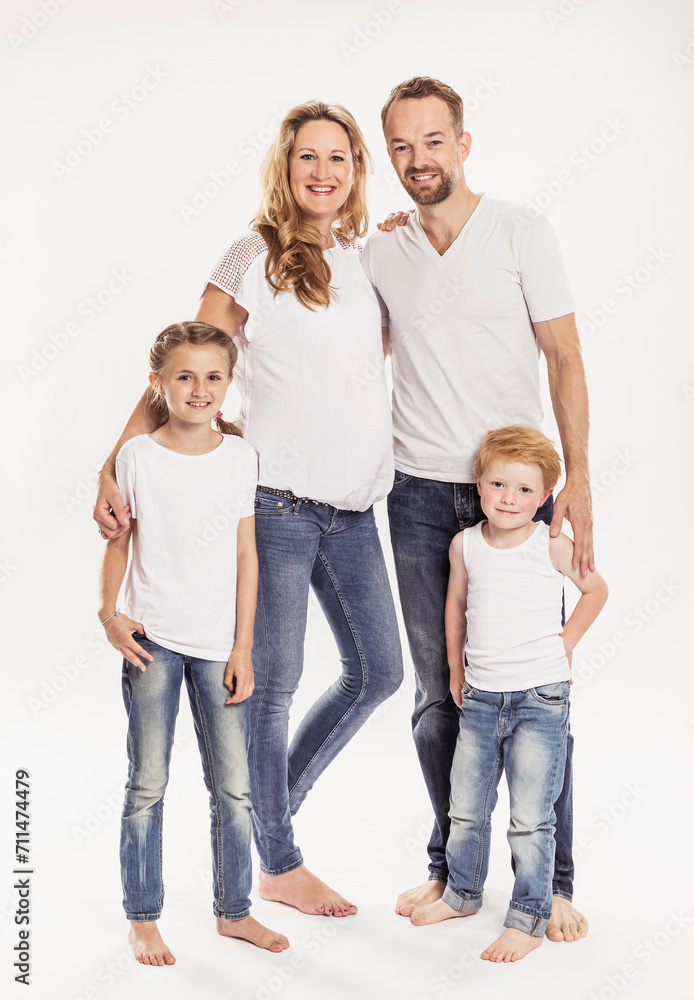 Studioportrait Familie mit zwei Kindern barfuss in Jeans lachen in die Kamera Studioportrait Familie mit zwei Kindern barfuss in Jeans lachen in die Kamera