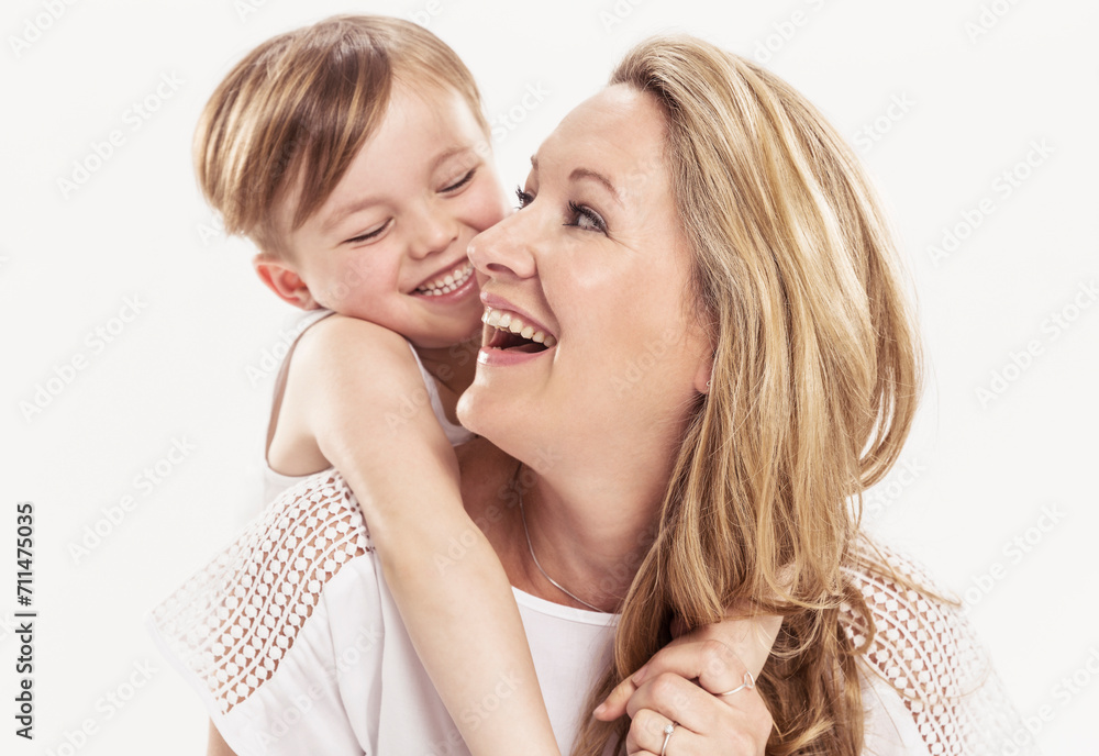 Studioportrait Mutter Kind barfuss in Jeans die sich gegenseitig anlachen Studioportrait Mutter Kind barfuss in Jeans die sich gegenseitig anlachen