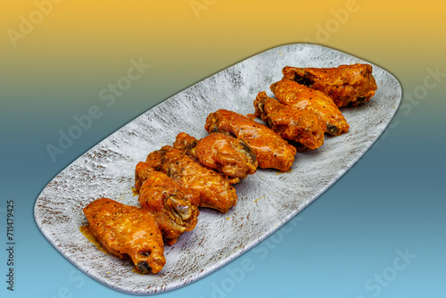 Plate of Buffalo chicken wings on a yellow and light blue background