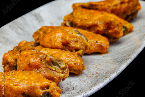 Plate of Buffalo chicken wings on a black background