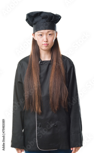 Young Chinese woman over isolated background wearing chef uniform depressed and worry for distress, crying angry and afraid. Sad expression.