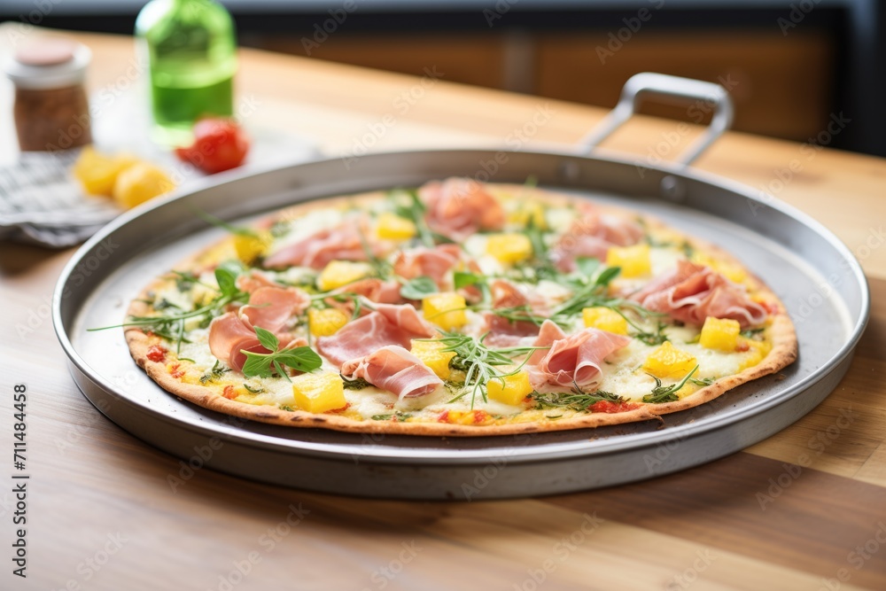 pizza with pineapple and ham on a steel tray