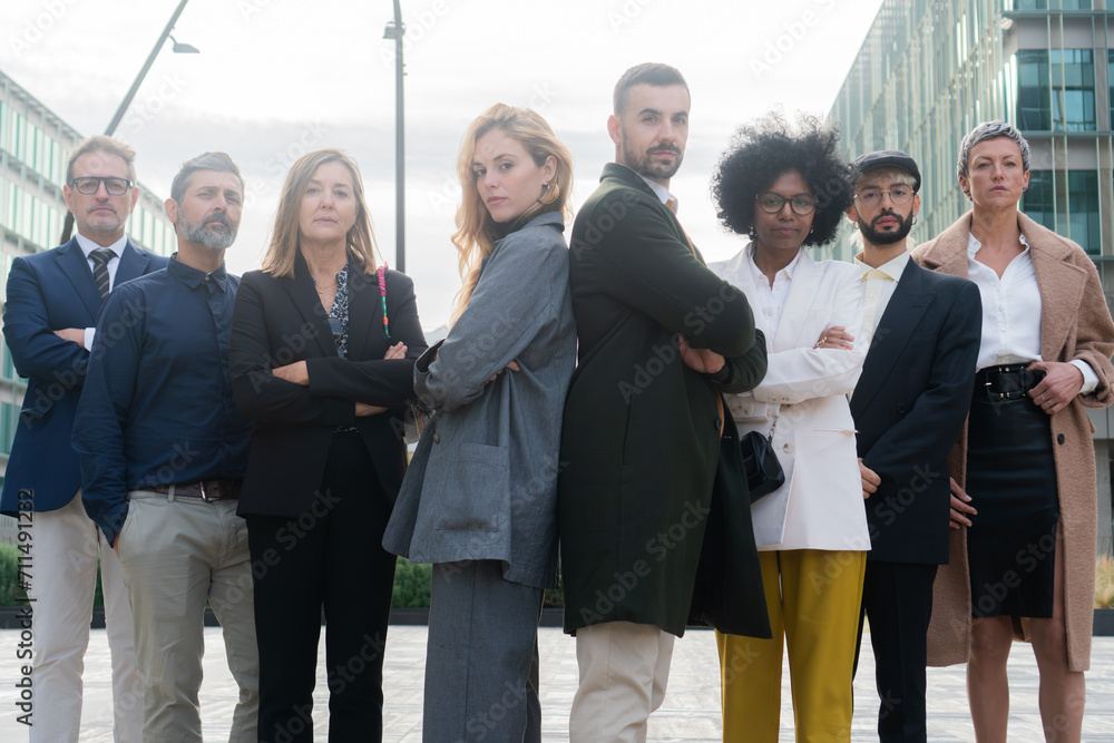 Multicultural team of businesswomen and businessmen looking atcamera with arms crossed looking confident and cooperative as a great coworkers posing outside the corporate company Multicultural team of businesswomen and businessmen looking atcamera with arms crossed looking confident and cooperative as a great coworkers posing outside the corporate company
