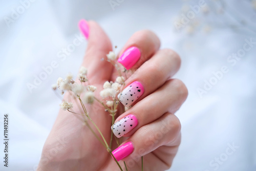 Women's hands with a fashionable pink manicure hold dried flowers in their hands. Spring - summer nail design photo