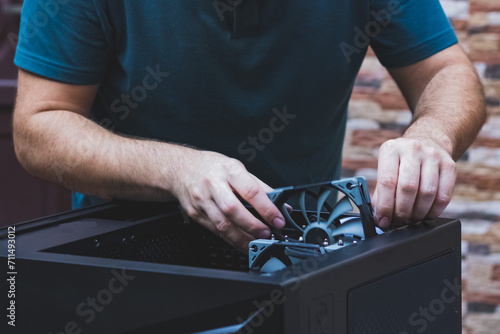 Hands of technician installs computer cooling element. Close up cleaning the pc cooler. Upgrade or PC assembly concept. Hardware components and technology background.