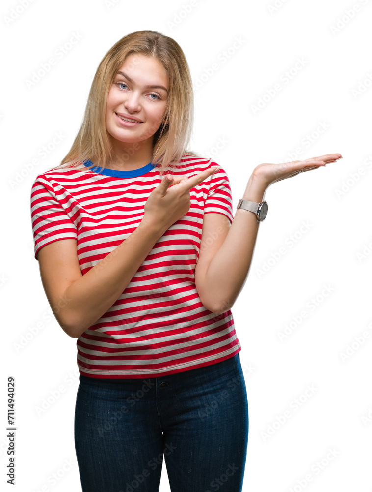 Young caucasian woman over isolated background amazed and smiling to the camera while presenting with hand and pointing with finger. Young caucasian woman over isolated background amazed and smiling to the camera while presenting with hand and pointing with finger.