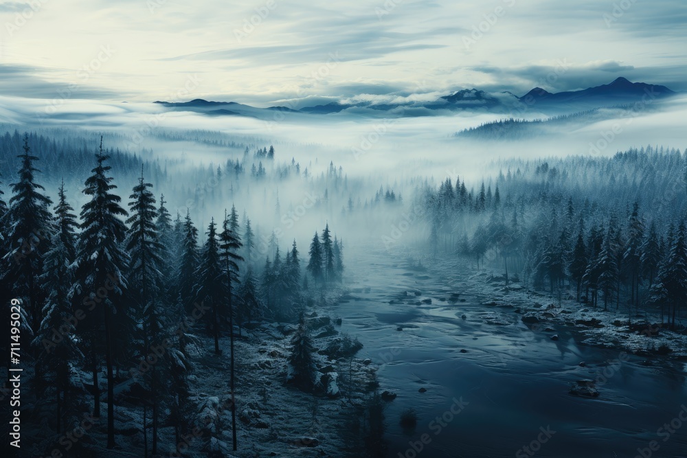 A winter wonderland of mist and fog envelops a majestic mountain landscape, as trees and a tranquil lake blend seamlessly into the wilderness