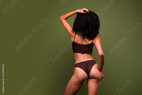 No filter back view photo of perfect sporty girl body plastic surgery aesthetic cosmetology empty space isolated on khaki color background
