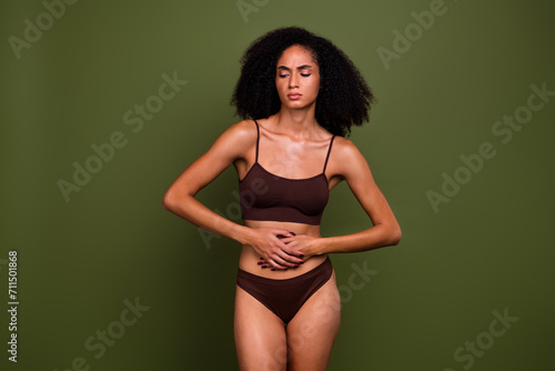 No filter photo of ill upset girl wearing brown lingerie suffering stomach pain isolated on khaki color background