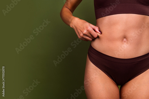 Cropped no filter photo of female arms pinching skin weight loss liposuction surgery empty space isolated on khaki color background