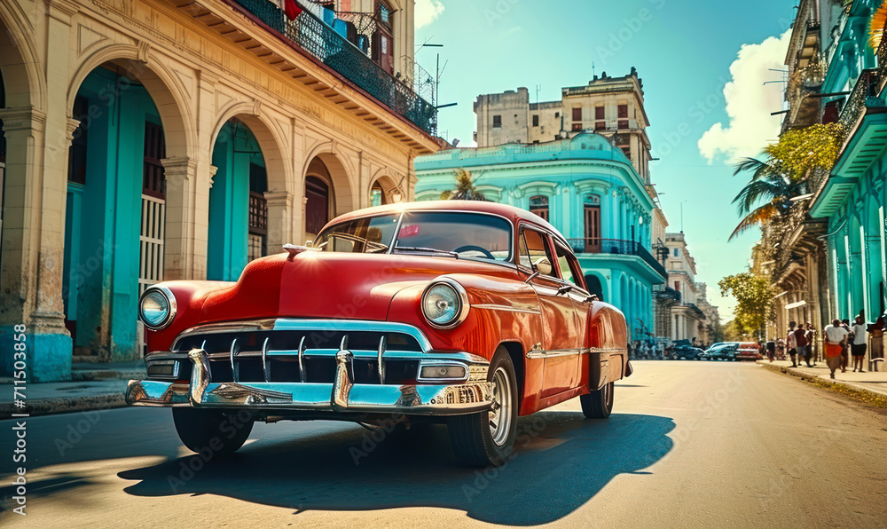 Obraz premium Vintage red classic car cruising on a sunny street in Havana with historical architecture and tropical vibes, capturing the essence of old Cuba