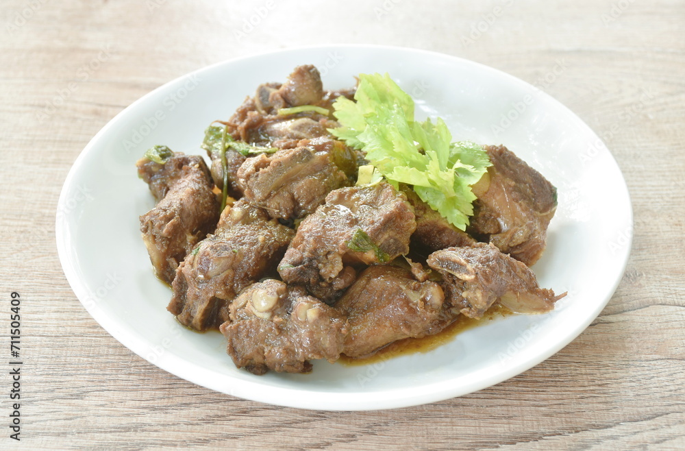 steamed pork bone with black sweet soy sauce topping celery on plate steamed pork bone with black sweet soy sauce topping celery on plate