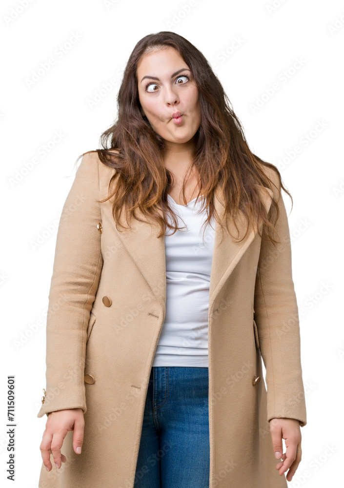 Beautiful plus size young woman wearing winter coat over isolated background making fish face with lips, crazy and comical gesture. Funny expression. Beautiful plus size young woman wearing winter coat over isolated background making fish face with lips, crazy and comical gesture. Funny expression.