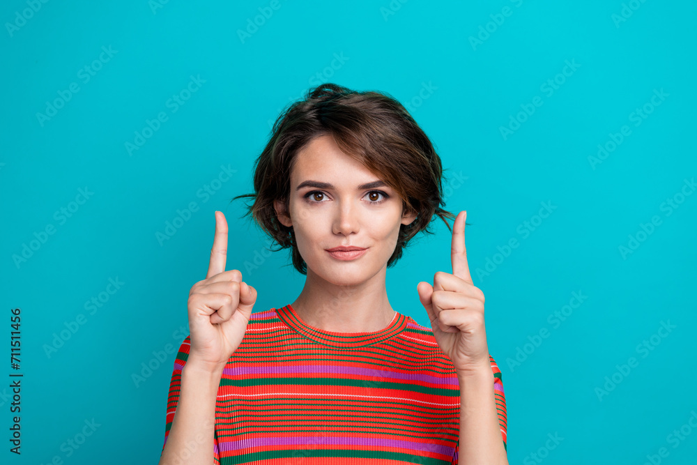 Photo of nice woman with short hairstyle dressed striped t-shirt indicating at offer empty space isolated on turquoise color background Photo of nice woman with short hairstyle dressed striped t-shirt indicating at offer empty space isolated on turquoise color background