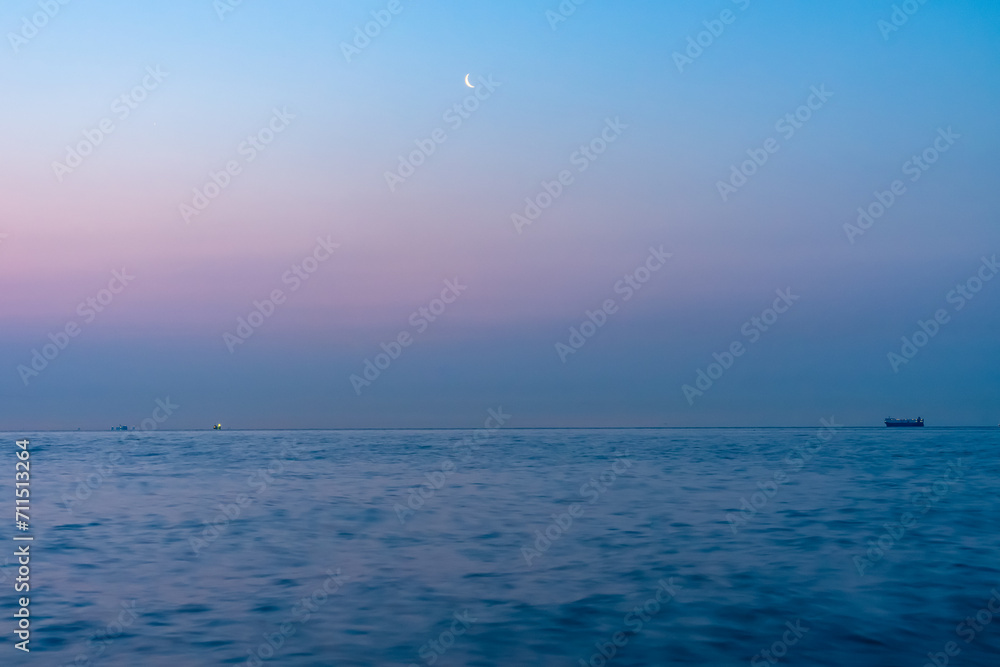 夜明けの空の月と海の船20210310