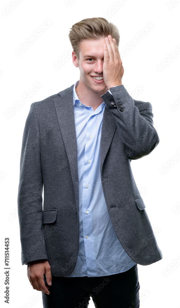 Young handsome blond business man covering one eye with hand with confident smile on face and surprise emotion. Young handsome blond business man covering one eye with hand with confident smile on face and surprise emotion.