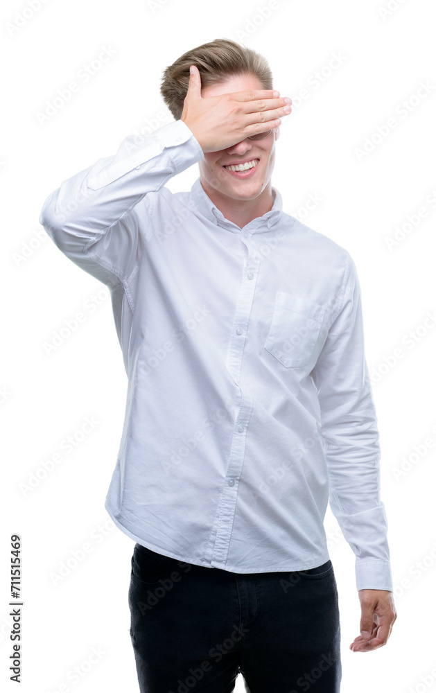 Young handsome blond man smiling and laughing with hand on face covering eyes for surprise. Blind concept. Young handsome blond man smiling and laughing with hand on face covering eyes for surprise. Blind concept.